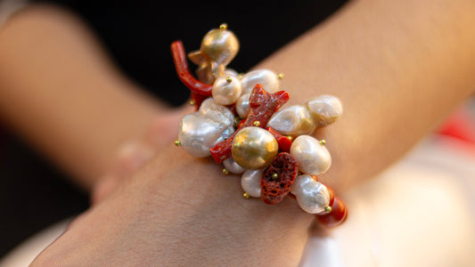 Bracciale RAWNA elasticizzato a grappolo con perle barocche bianche, rametti di corallo naturale rosso e dettagli dorati, stile mediterraneo