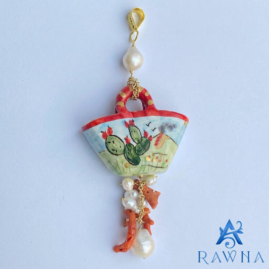Ciondolo artigianale in ceramica a forma di coffa siciliana dipinta a mano con paesaggio, perle coltivate bianche e rametti di corallo rosso pendente - RAWNA